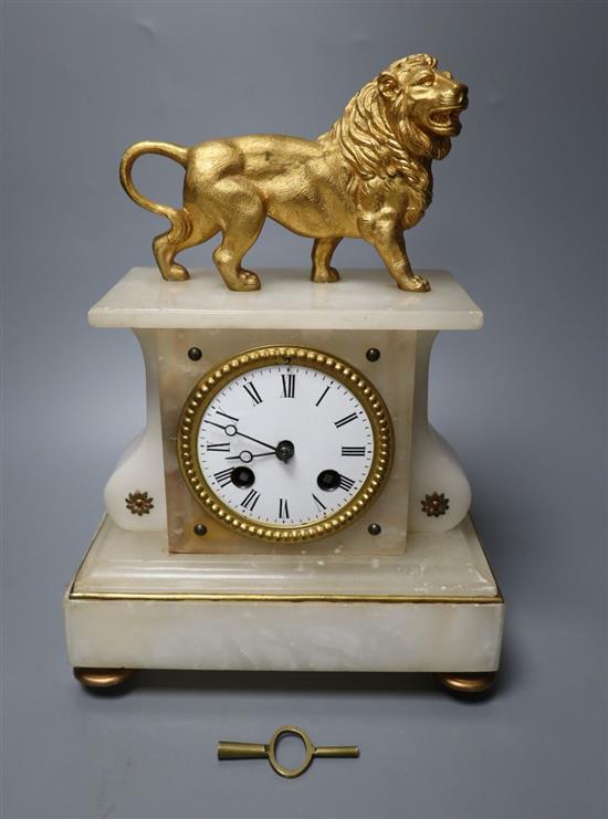 A 19th century French eight day alabaster mantel clock, surmounted by a gilt metal model of a lion, bell striking movement, 30cm